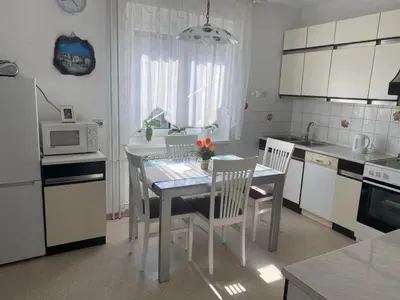 a kitchen with a table and chairs and a microwave at Hiša Tavčar in Dutovlje