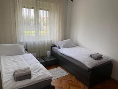 two twin beds in a room with a window at Hiša Tavčar in Dutovlje