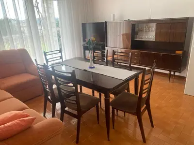 a living room with a table and chairs and a television at Hiša Tavčar in Dutovlje