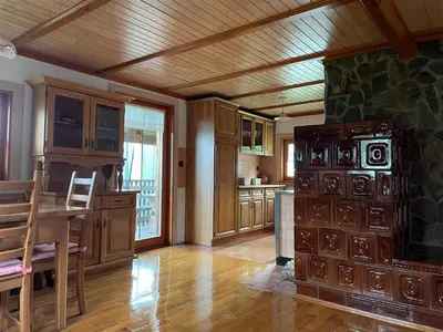 a large kitchen with a wooden ceiling and a table at Sedmakovo - Počitniška hiša v naravi - Ljubno ob Savinji in Ljubno