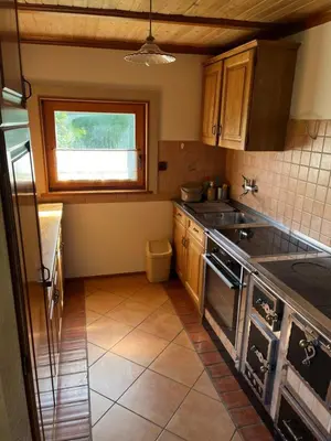 a kitchen with a stove and a sink and a window at Sedmakovo - Počitniška hiša v naravi - Ljubno ob Savinji in Ljubno