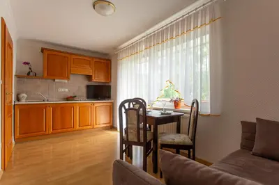 a living room with a table and a kitchen at Gostišče Pri Dveh Petelinih in Bled