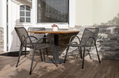 a table and chairs in front of a brick wall at Gostišče Pri Dveh Petelinih in Bled