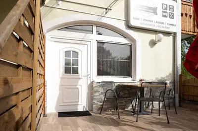 a patio with a table and chairs and a door at Gostišče Pri Dveh Petelinih in Bled