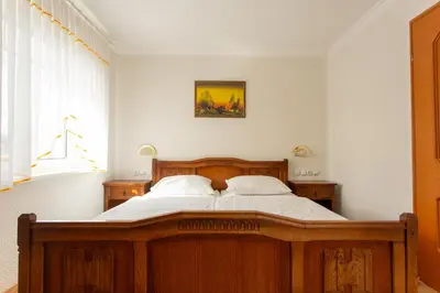 a bedroom with a wooden bed with two pillows at Gostišče Pri Dveh Petelinih in Bled