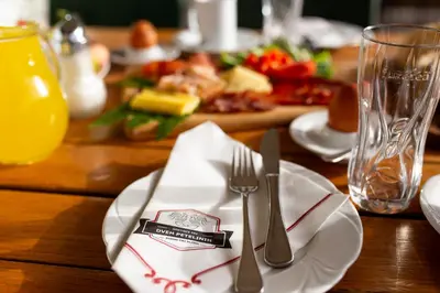 a table with a plate of food with a fork and knife at Gostišče Pri Dveh Petelinih in Bled