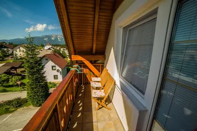 a balcony with a bench and a view of the mountains at Gostišče Pri Dveh Petelinih in Bled