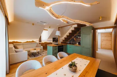 a kitchen and living room with a table and chairs at Menart Estate apartments in Cerklje na Gorenjskem
