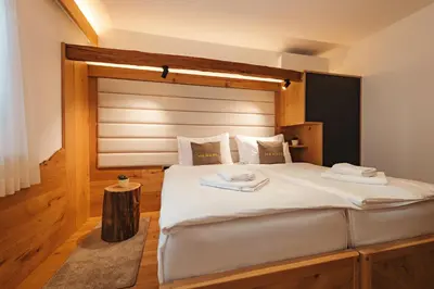 a bedroom with a large white bed with a wooden headboard at Menart Estate apartments in Cerklje na Gorenjskem