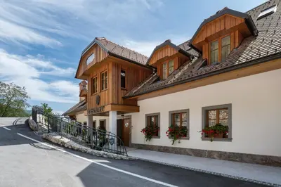 a house with wooden trim and windows on a street at Menart Estate apartments in Cerklje na Gorenjskem
