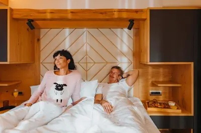 a man and a woman laying in bed at Menart Estate apartments in Cerklje na Gorenjskem