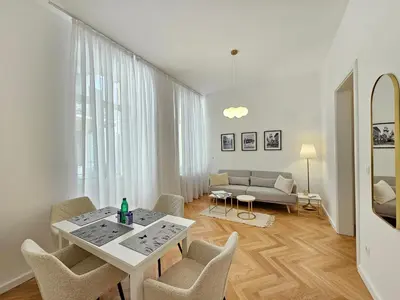 a white living room with a table and chairs at Urban Nest Wolfova by the Triple Bridge in Ljubljana