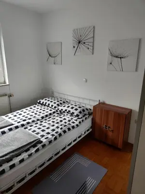 a bedroom with a bed and two pictures on the wall at Designer apartment in nature in Vojnik