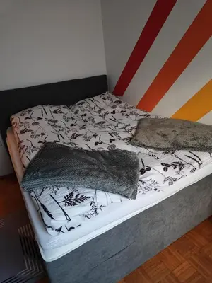 a bed with black and white blankets on it at Designer apartment in nature in Vojnik