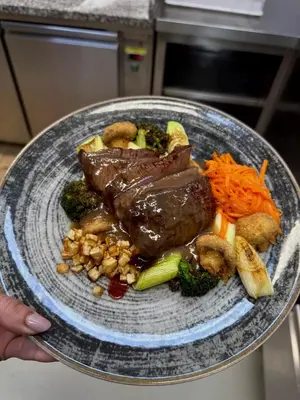 a plate of food with meat and vegetables on it at Prenočišča Zvezda in Ljutomer