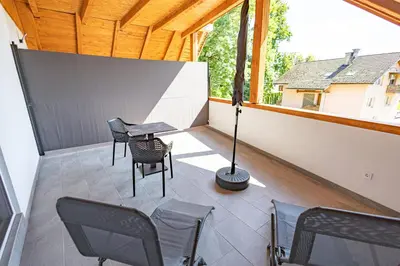 a patio with chairs and a table and a lamp at Apartma Pr' Bavnč in Lesce
