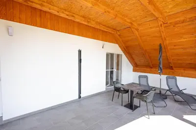 a room with a table and chairs and a wooden ceiling at Apartma Pr' Bavnč in Lesce