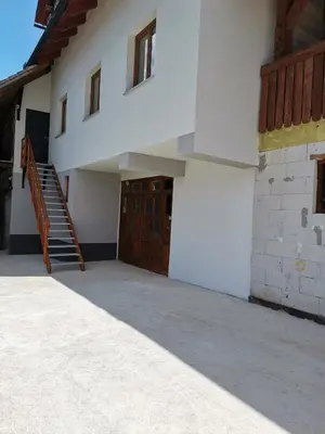 a large white building with a staircase and a door at Apartma Pr' Bavnč in Lesce