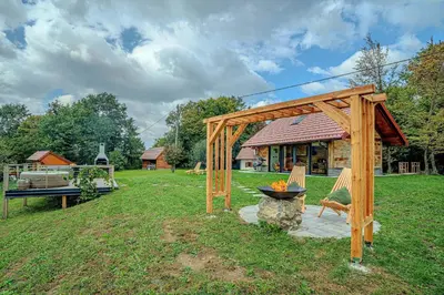 a wooden pergola and a fire pit in a yard at Vineyard cottage Pri mali luži in Trebelno