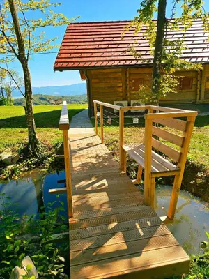 a wooden walkway leading to a cabin with a bench at Vineyard cottage Pri mali luži in Trebelno