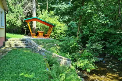 a garden with a bench and a stone wall at Apartment Vintgar in Slovenska Bistrica
