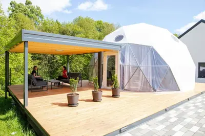 a dome tent on a deck with two people sitting in at Cozy Fizio Dome in Gradišče v Slovenskih Goricah