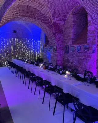 a long table in a brick room with purple lights at Cozy Fizio Dome in Gradišče v Slovenskih Goricah