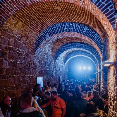 a crowd of people walking through a brick tunnel at Cozy Fizio Dome in Gradišče v Slovenskih Goricah