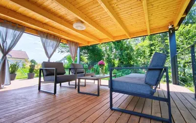 a patio with chairs and a table on a wooden deck at Cozy Fizio Dome in Gradišče v Slovenskih Goricah