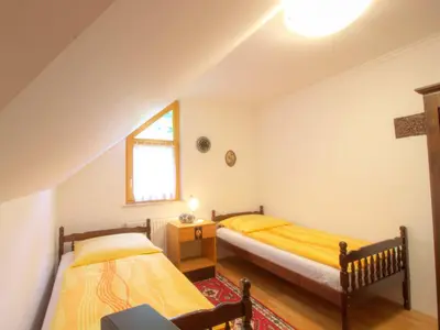 two twin beds in a room with a window at Apartments Mira in Bled