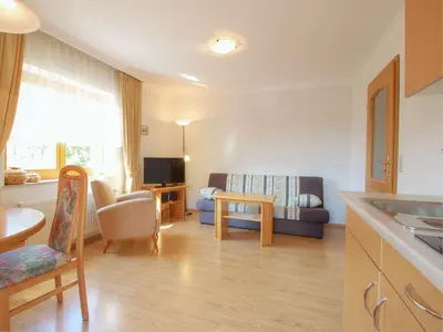 a kitchen and living room with a couch and a table at Apartments Mira in Bled