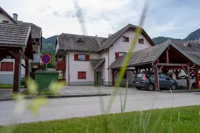 a house with a car parked in a parking lot at Apartma Igor in Bohinj