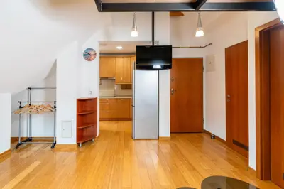a kitchen with a refrigerator and a tv on a wall at Apartma Igor in Bohinj
