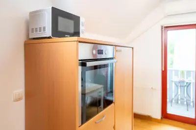 a tv on top of a wooden cabinet with a microwave at Apartma Igor in Bohinj