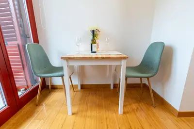 a white table with two chairs and a vase on it at Apartma Igor in Bohinj