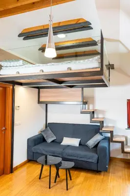 a living room with a couch under a loft bed at Apartma Igor in Bohinj