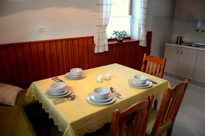 a table with a yellow table cloth and dishes on it at Anna's House in Bled