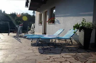 a group of blue chairs and a table on a patio at Anna's House in Bled