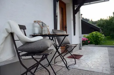 a chair and a table on the side of a house at Anna's House in Bled