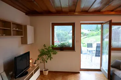 a living room with a tv and a sliding glass door at Anna's House in Bled