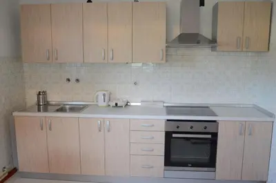 a kitchen with wooden cabinets and a sink and a stove at Anna's House in Bled