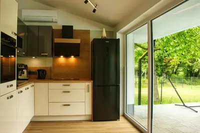 a black refrigerator in a kitchen with a sliding glass door at Relax Apartma in Gornja Radgona