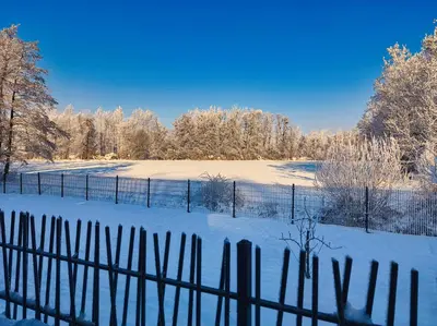 a fence in a field covered in snow at Relax Apartma in Gornja Radgona