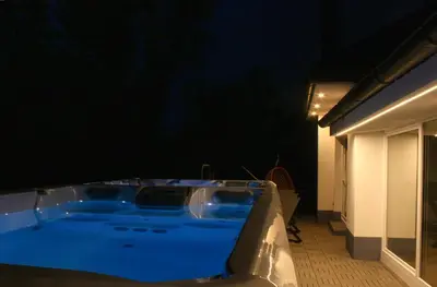 a jacuzzi tub in a room with a dark wall at Relax Apartma in Gornja Radgona