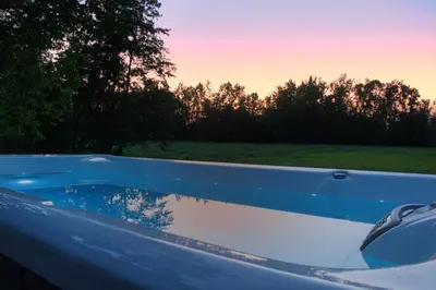 a bath tub filled with water next to a field at Relax Apartma in Gornja Radgona