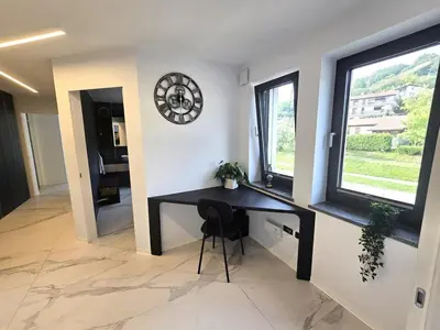 a black desk in a room with a clock on the wall at Rozna Retreat in Nova Gorica