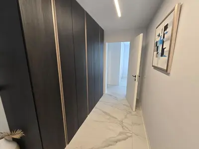 a hallway with a dark wood cabinet and a hallway with a marble floor at Rozna Retreat in Nova Gorica