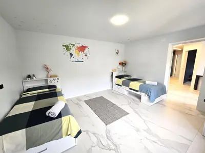 two beds in a room with white walls at Rozna Retreat in Nova Gorica