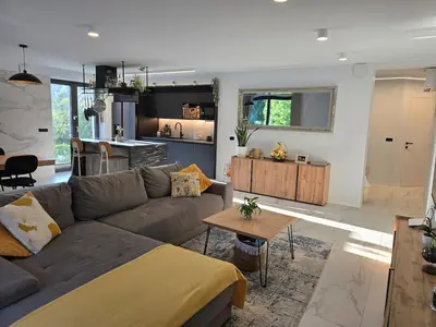a living room with a couch and a kitchen at Rozna Retreat in Nova Gorica