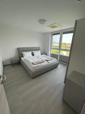 a bedroom with a bed and a large window at Apartments Lux in Spodnja Hajdina